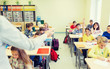 © Syda Productions - group of school kids raising hands in classroom