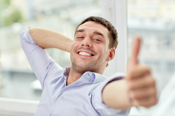 Canvas Print - smiling man showing thumbs up at home or office