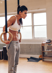 Wall Mural - Sports woman working out with gymnastic ring