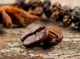 Coffee grains and green leaf on grunge wooden background