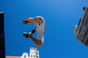 Poster -  Extreme athlete jumping in the air in front of a building