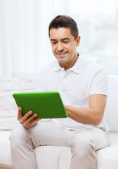 Sticker - smiling man working with tablet pc at home