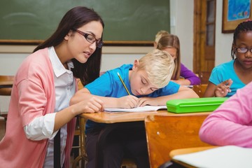 Wall Mural - Smiling teacher helping a student