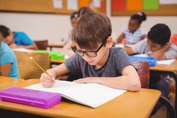 Little boy working at his desk in class