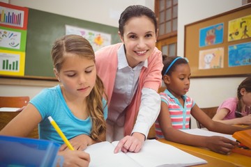 Wall Mural - Pupil and teacher at desk in classroom