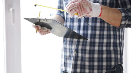 Wall Mural - close up of man with measuring ruler and clipboard