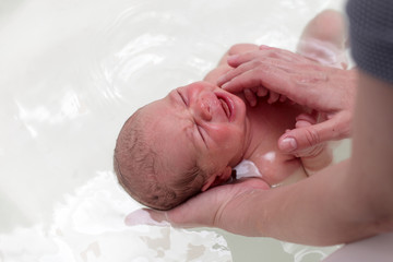 Newborn baby crying in the bath