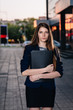 © ruslan1117 - Successful businessman, standing against the backdrop of buildings holding  folder with sales charts. City business woman working.