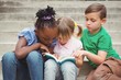 © WavebreakMediaMicro - Students sitting on steps and reading a book