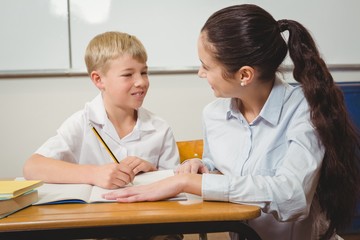 Wall Mural - Teacher helping a student in class