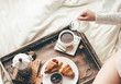 © nioloxs - Woman having breakfast in bed. Window light