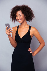 Sticker - Smiling afro american woman using smartphone