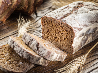 Wall Mural - Sliced black bread on the wooden plank.