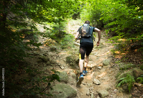 Fotomural trail runner with backpack running up the steep hill