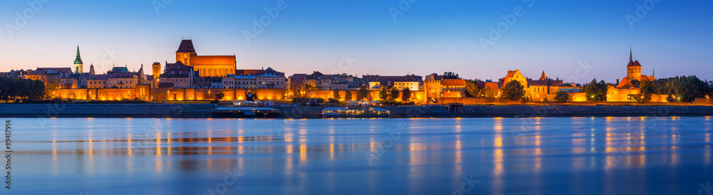 Obraz na płótnie Panorama of Torun at night reflected in Vistula river, Poland w salonie