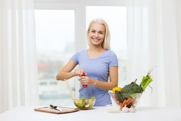 Wall Mural - smiling woman cooking vegetable salad at home