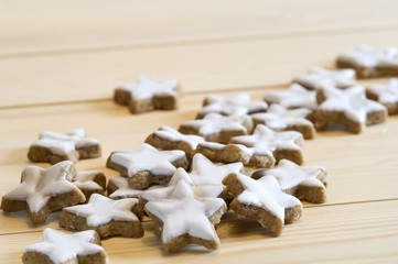 Wall Mural - Star-shaped cinnamon biscuits on a wooden surface