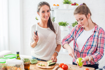 Wall Mural - Women preparing dinner in a kitchen concept dieting healthy food