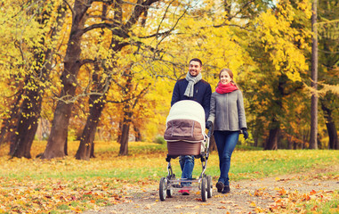 Poster - smiling couple with baby pram in autumn park