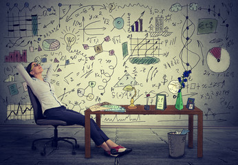 Young business woman relaxing at her desk in her office