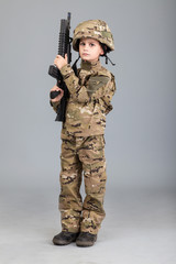 Wall Mural - Young boy dressed like a soldier with rifle