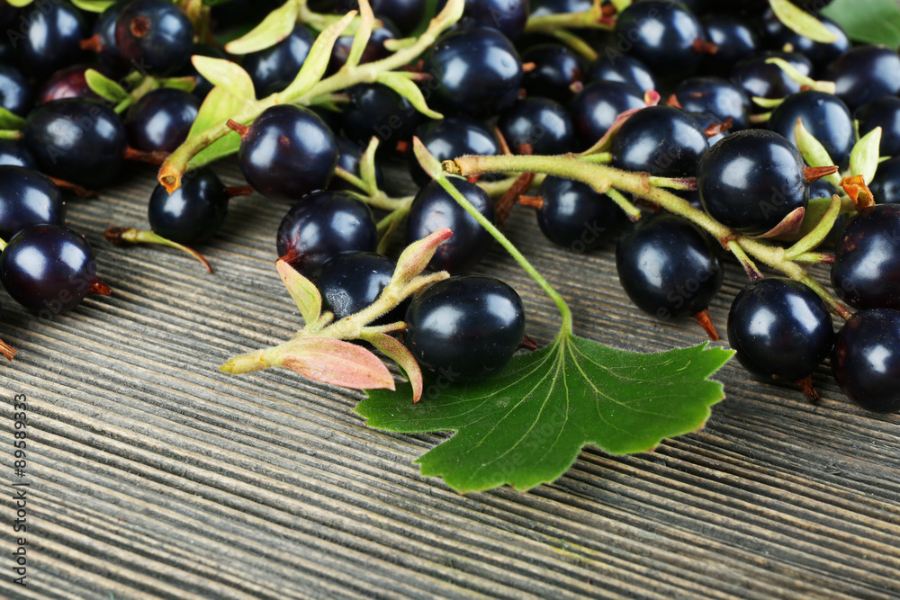 Pile of black currants on wooden table, closeup