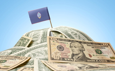 Wall Mural - Flag of Guam sticking in a pile of american dollars.(series)