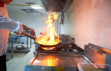 Wall Mural - chef in hotel kitchen prepare food with fire