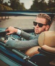Confident Wealthy Young Man Behind Classic Convertible Steering Wheel