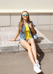 Wall Mural - Pretty smiling woman wearing a sunglasses and jeans clothes with