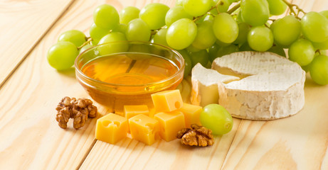 Wall Mural - Still life of cheese, honey, walnuts and grapes