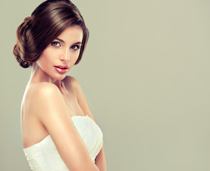 Girl model in a white wedding dress with elegant hairstyle 
