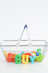 Buy or purchase concept with magnetic letters on a shopping basket