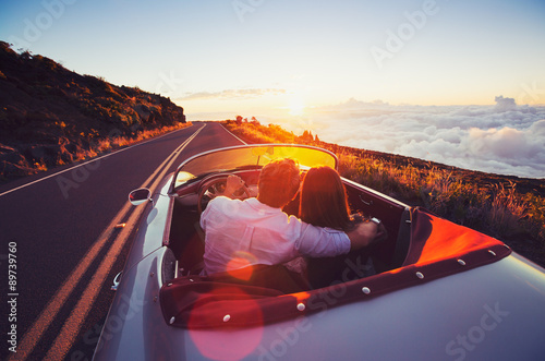 Fotografia, Obraz Romantic Couple Driving on Beautiful Road at Sunset
