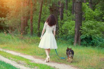 Young bride walking with dog on the rural road