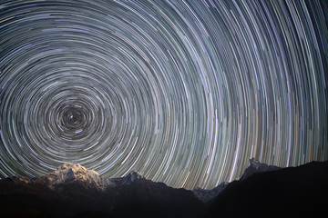 Wall Mural - spinning universe. star trails over the snowy mountains.