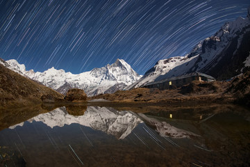 Wall Mural - start trails over the snowy mountains near the lake.