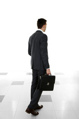 Wall Mural - Man holding suitcase on light background