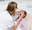 © Ermolaev Alexandr - little girl having his throat examined by health professional