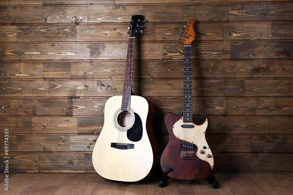 Electric and acoustic guitars on wooden background