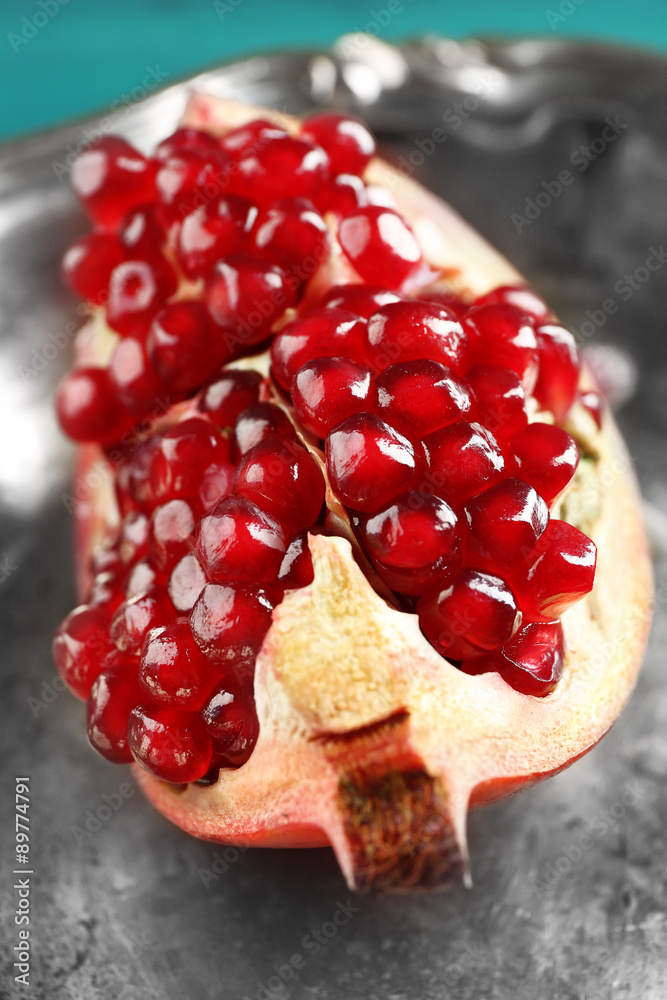 Juicy pomegranate on metal tray, closeup