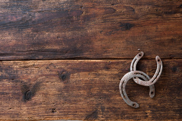 Two old rusty horseshoe on vintage wooden board