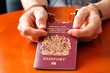 Illegal immigration concept with hands holding UK passport