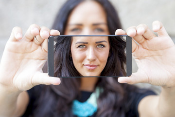 pretty woman with gray eyes take a selfie with smart phone