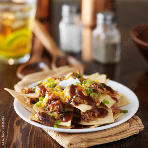 Cuadros en Lienzo barbecue pulled pork nachos with sourcream, green onions and melted cheese