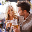 © Joshua Resnick - romantic couple drinking beer in outdoor pub or bar making a toast