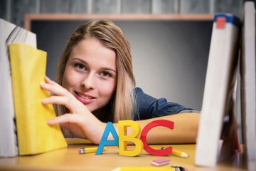 Canvas Print - Composite image of pretty student in the library