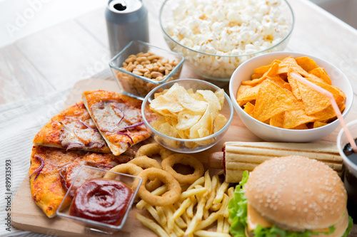 close up of fast food snacks and drink on table © Syda Productions