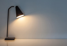 The Modern Desk Lamp Illuminate On The Wall Background.