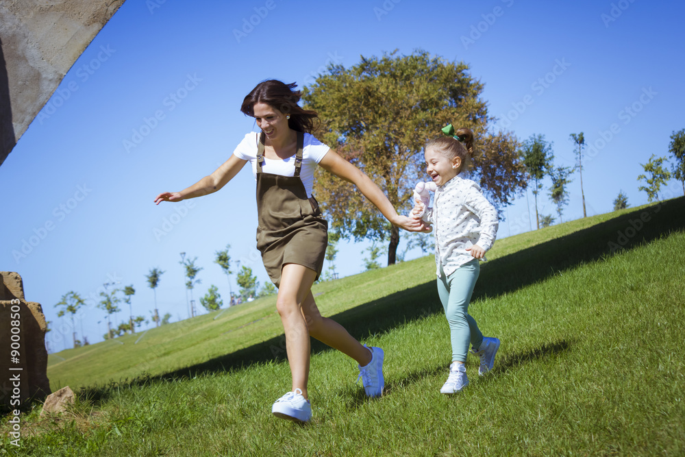 Foto de Stock Una niña y su mama corriendo por el parque. Madre e hija ...